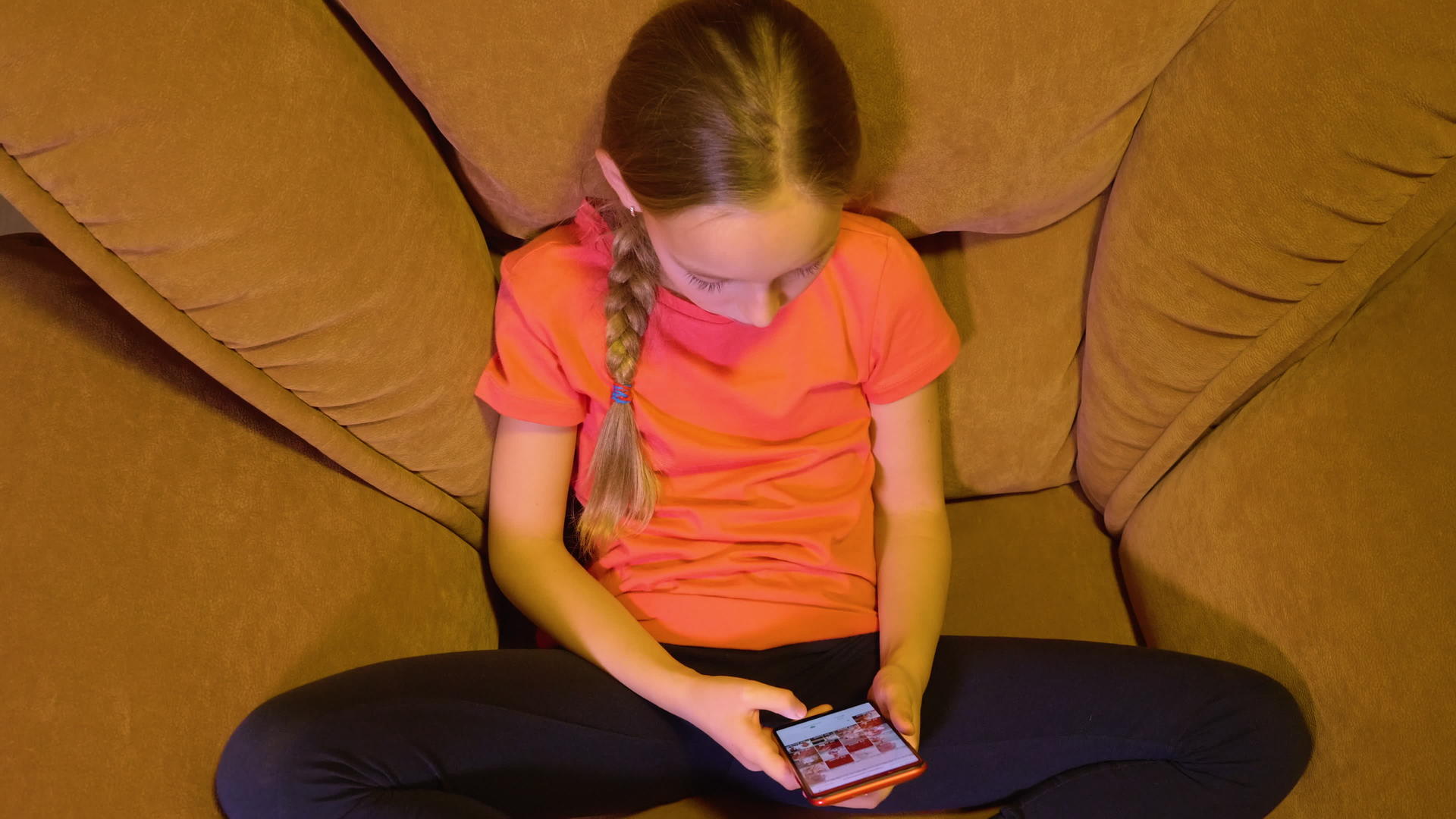 快乐的女孩在社交媒体上用智能手机用舒适的椅子拍照视频的预览图