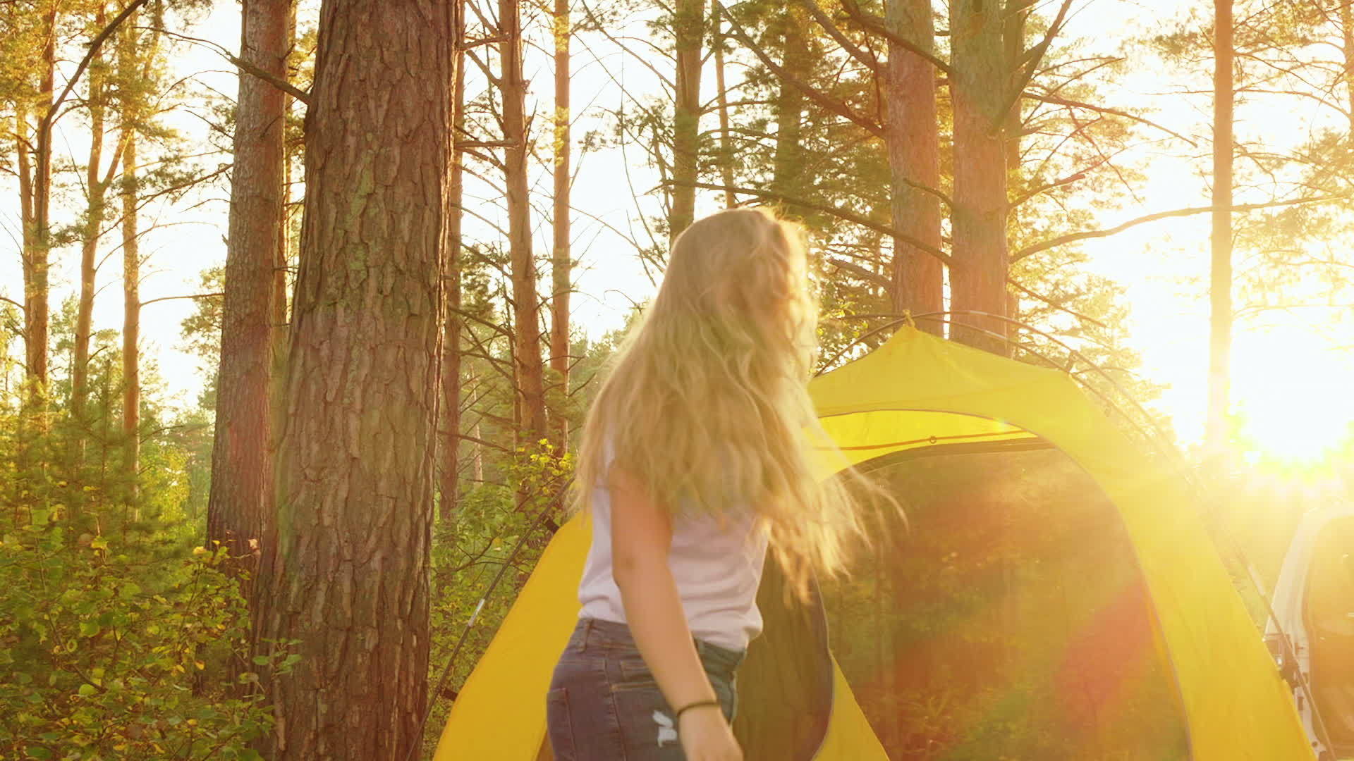 快乐的女孩和男孩在阳光明媚的森林露营帐篷背景下视频的预览图
