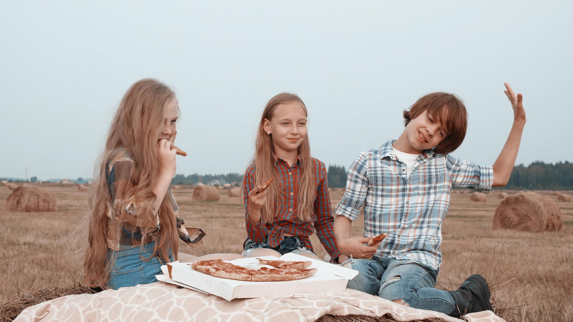 三个快乐的孩子在野外吃披萨视频的预览图