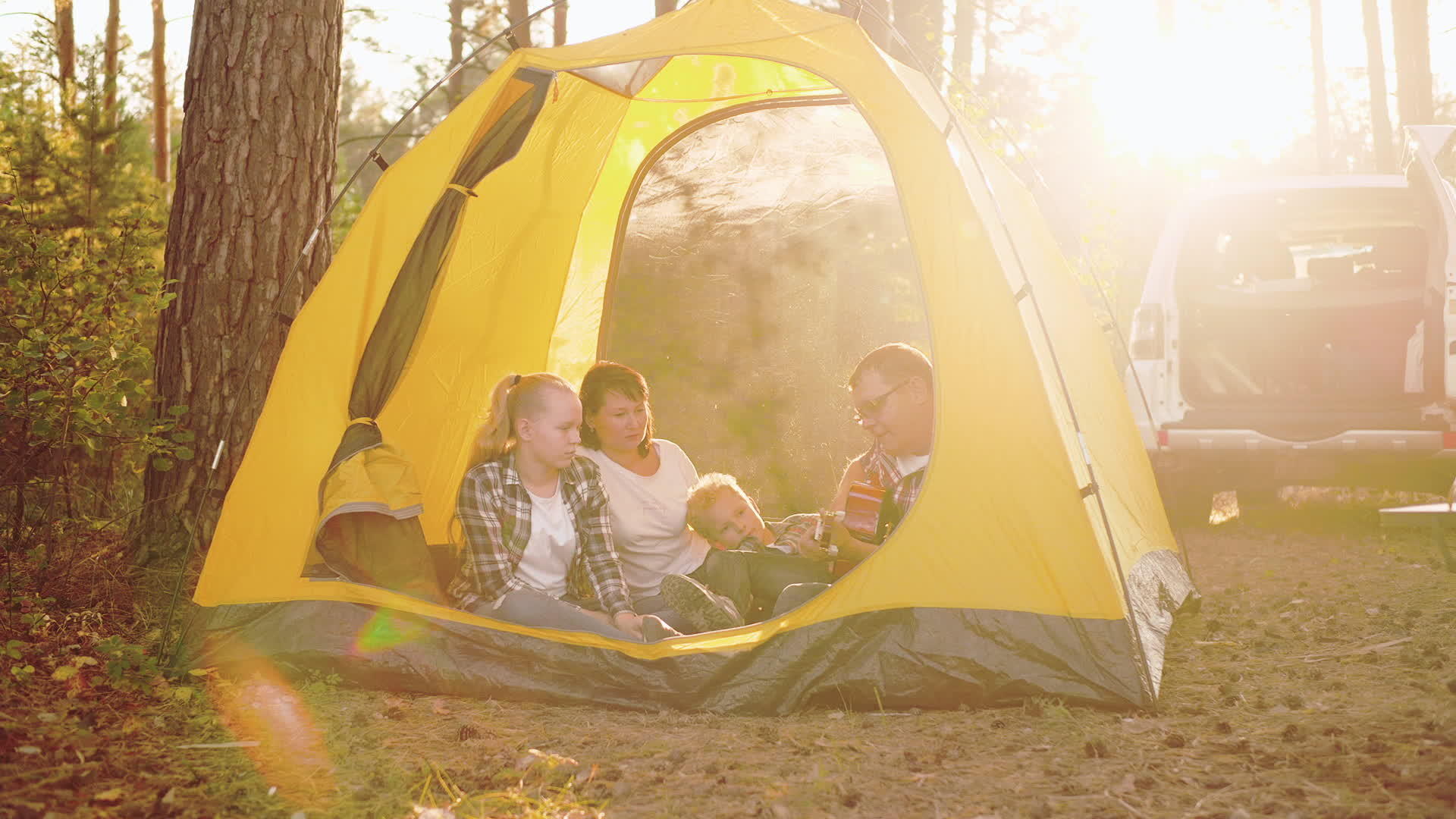家庭幸福坐在森林帐篷里视频的预览图