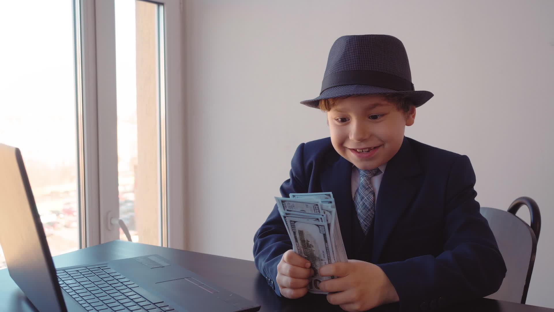 快乐的年轻商人手里拿着钱坐在办公室的桌子上视频的预览图