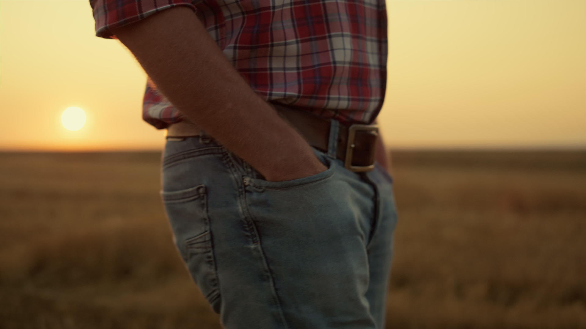 在金色的日落特写镜头中不知名的农民走在空旷的田野上视频的预览图