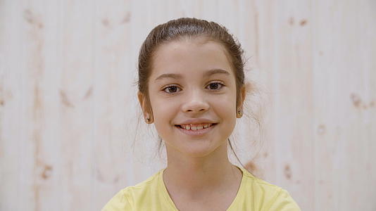 快乐微笑的女孩肖像性格开朗的女孩在灯光下露出牙齿的微笑视频的预览图