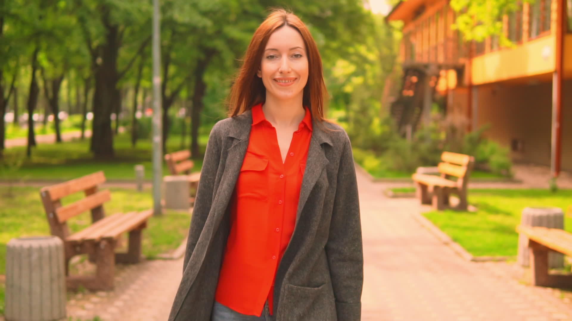 一个微笑的年轻女子在城市公园里散步视频的预览图