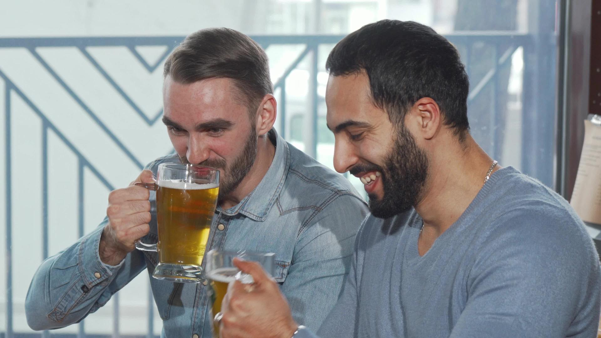 快乐的男性朋友在酒吧里喝啤酒杯视频的预览图