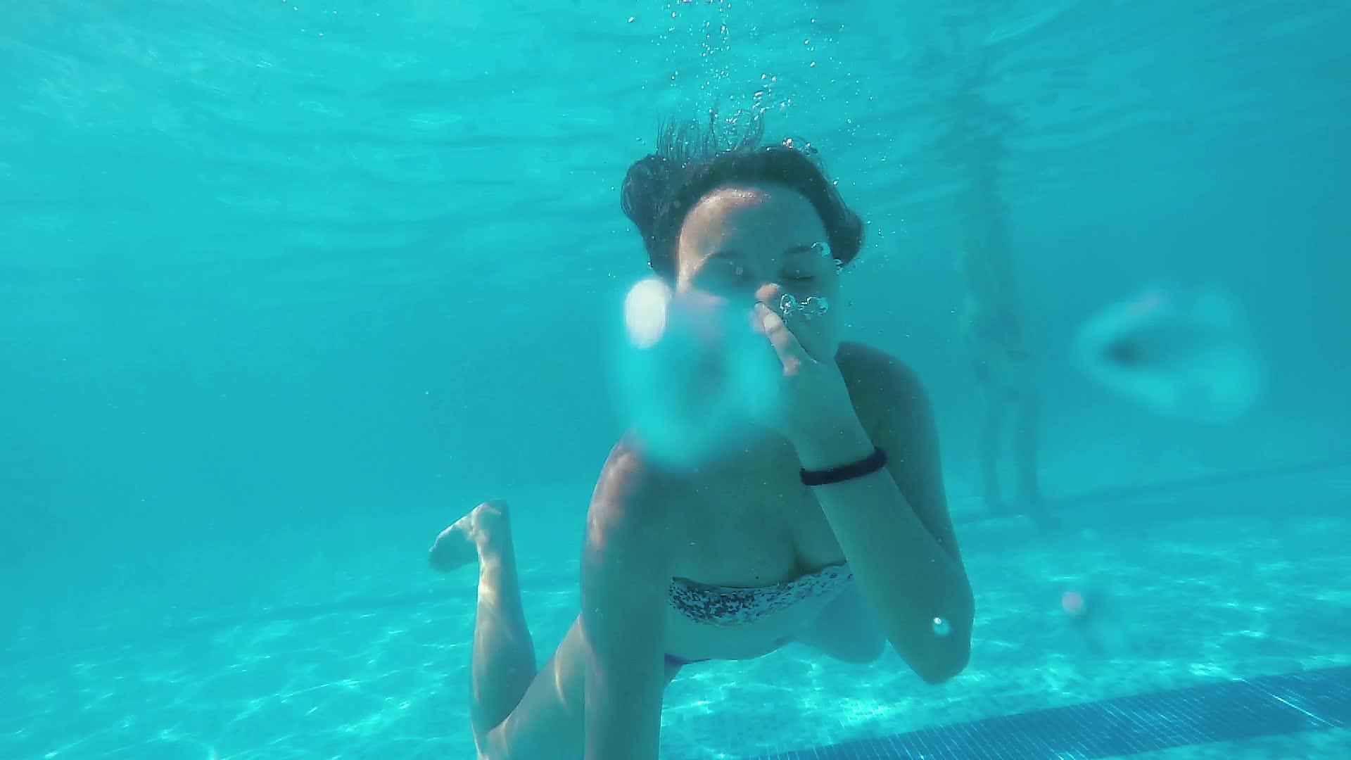 迷人的青少年去游泳池游泳用清水装扮成相机微笑视频的预览图