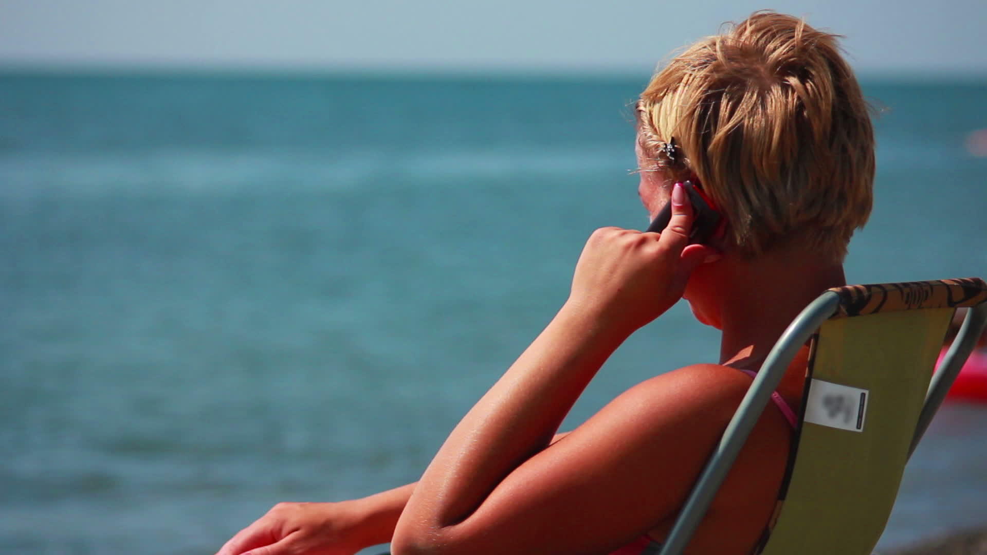 女人在海滩的电话里说话视频的预览图