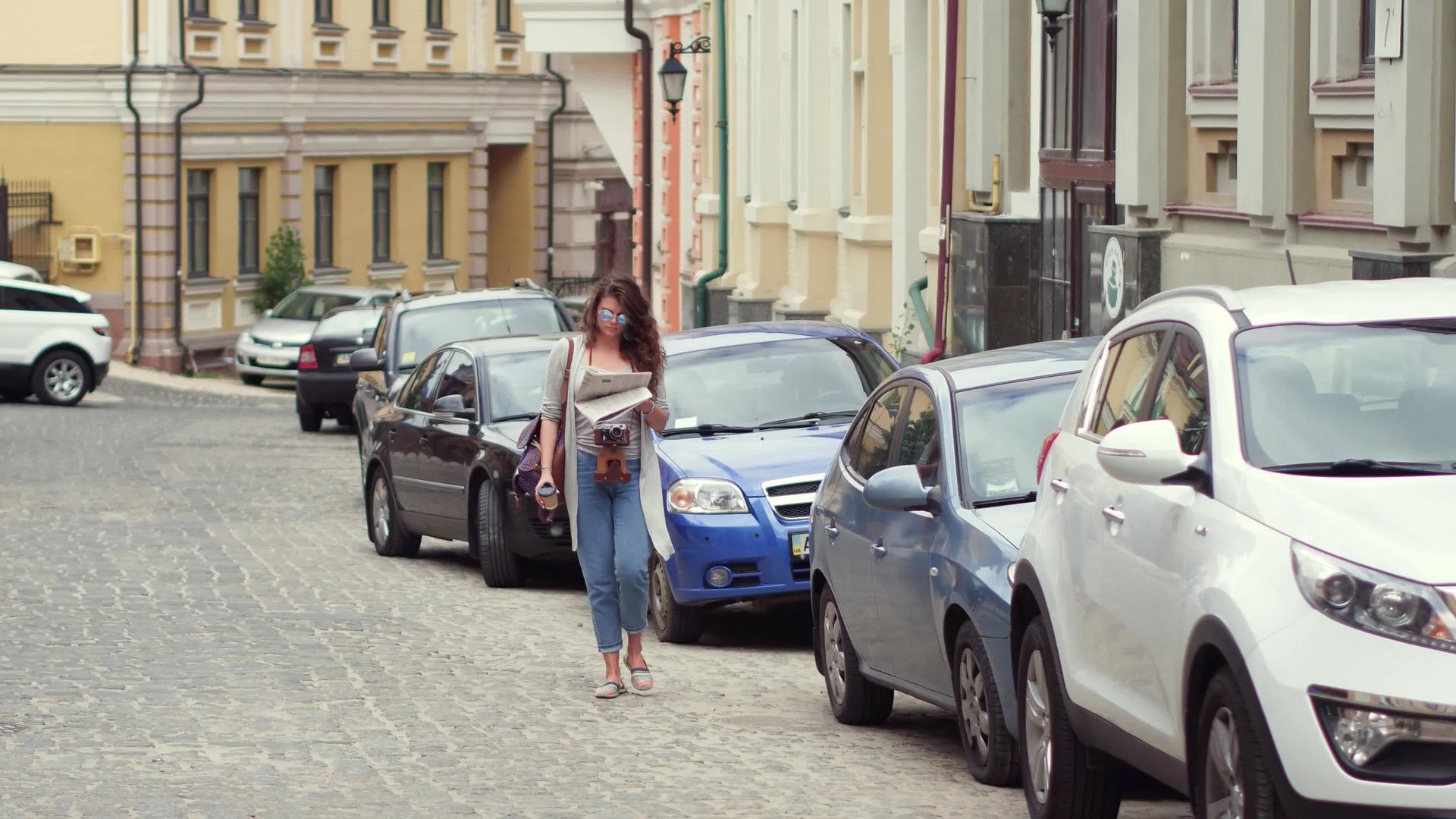 旅行女孩在街上散步喝咖啡看报纸视频的预览图