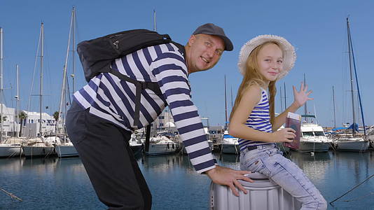 快乐的父亲和女儿坐在手提箱上在港口巡航视频的预览图