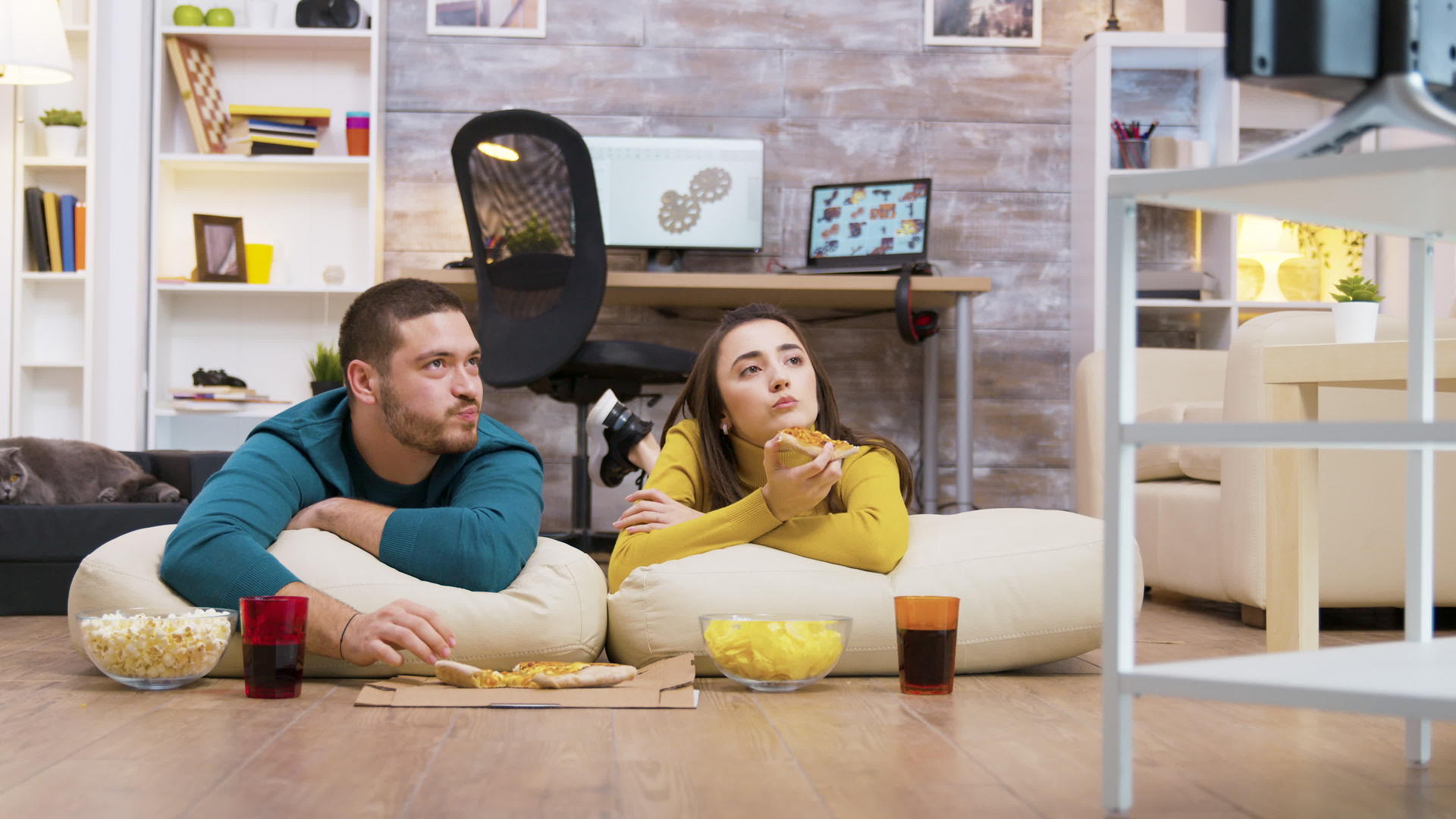 一对快乐的夫妇坐在枕头上吃披萨caucasians情侣视频的预览图