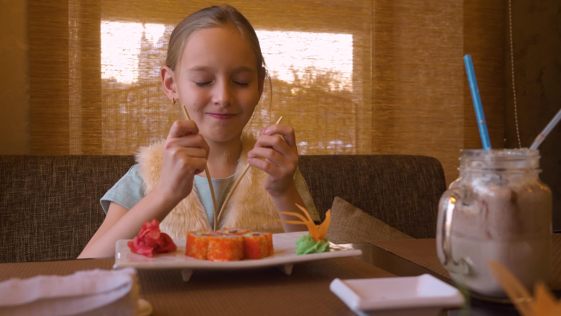 快乐的女孩在亚洲西餐厅吃寿司分享筷子视频的预览图