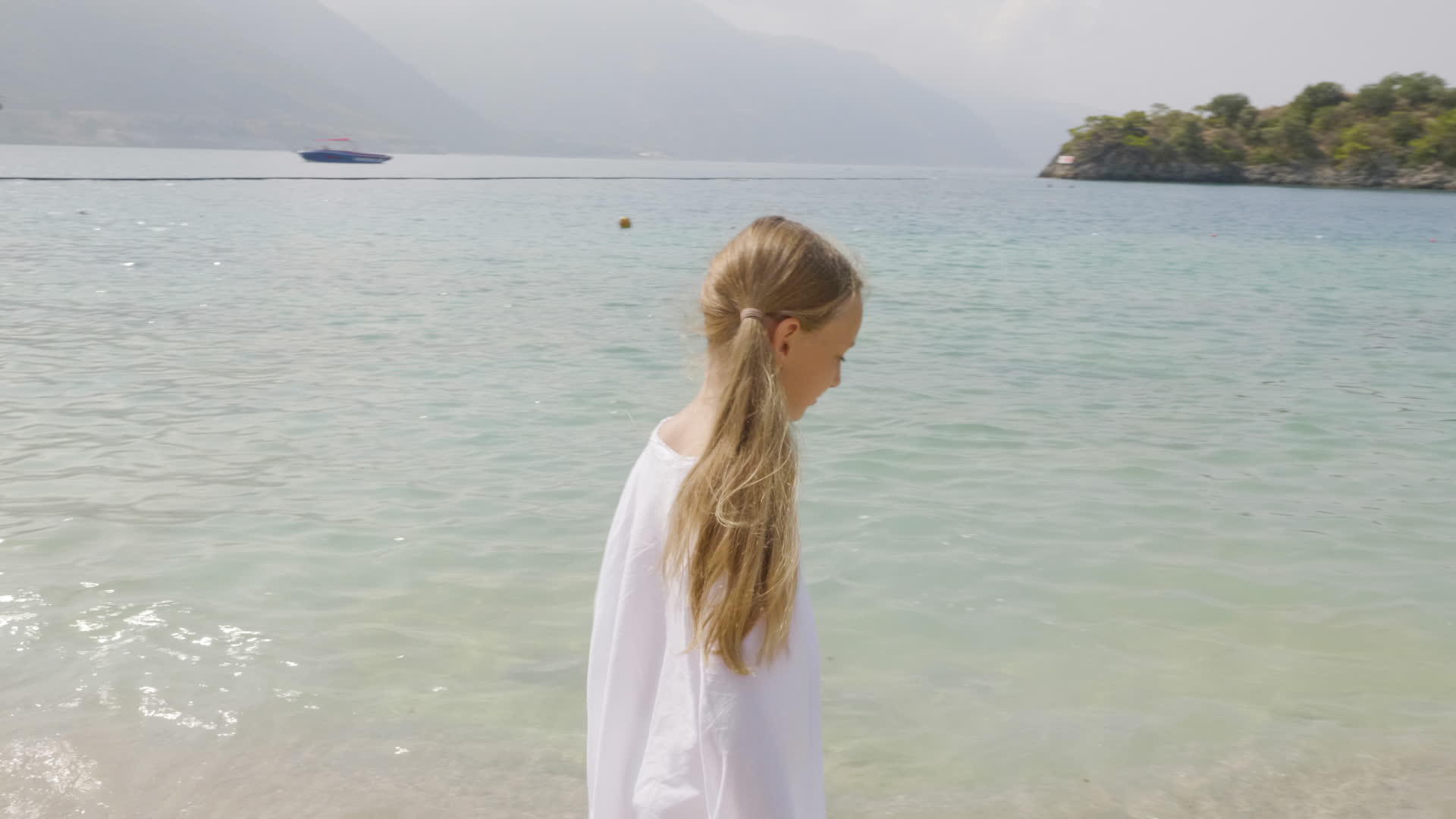快乐的女孩穿着白色的衣服在海滩上散步女孩在夏天的海滩上旅行视频的预览图
