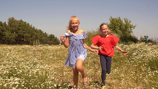 快乐的女孩在夏天乡村的绿色田野上奔跑性格开朗的女孩视频的预览图