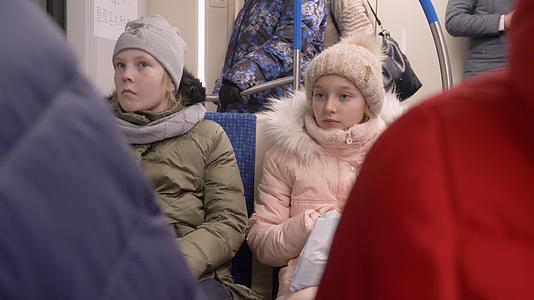 两个快乐的女孩坐在火车里在城市地铁上骑马视频的预览图