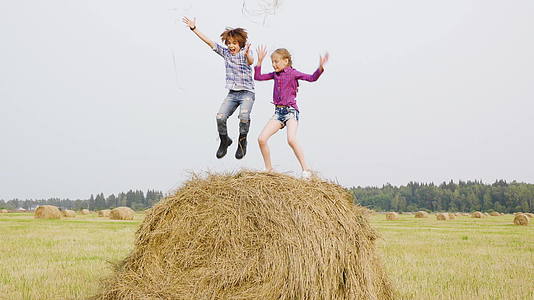 快乐的青少年在干草堆上吐干稻草无忧无虑的男孩和女孩视频的预览图