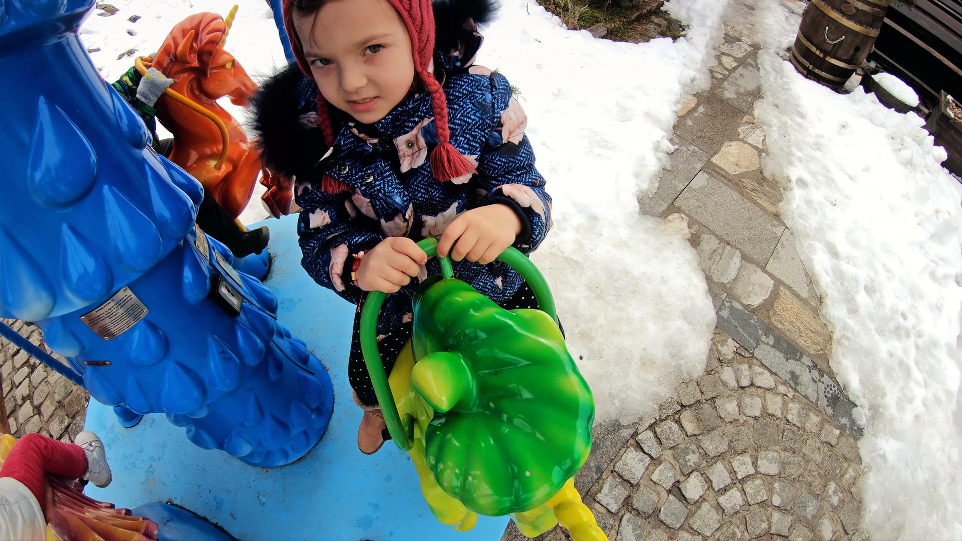 快乐的小女孩在冬天的雪中享受户外旋转木马的乐趣视频的预览图