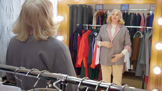 购物时快乐的女人在服装店试穿新夹克视频的预览图