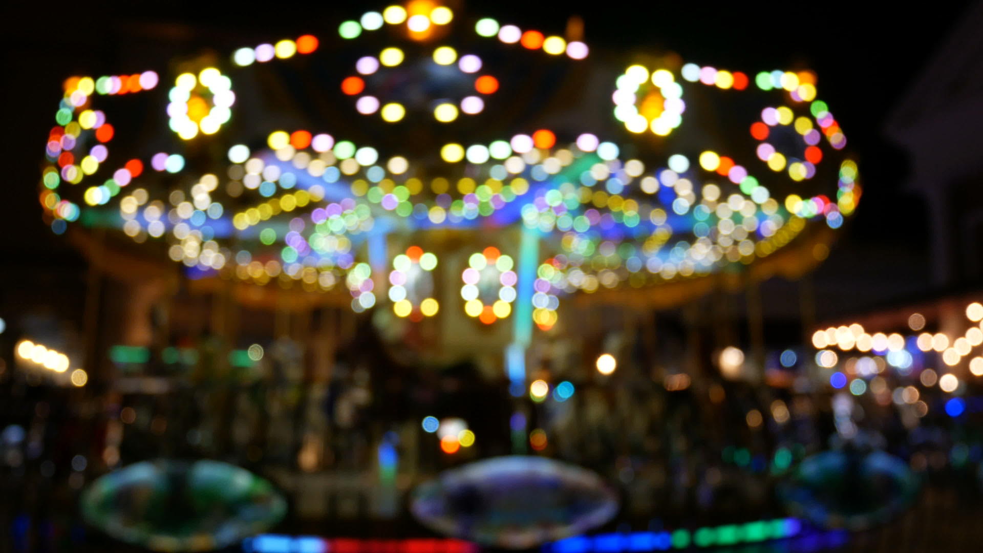 孩子们在晚上骑旋转木马来庆祝节日bokeh灯为背景视频的预览图