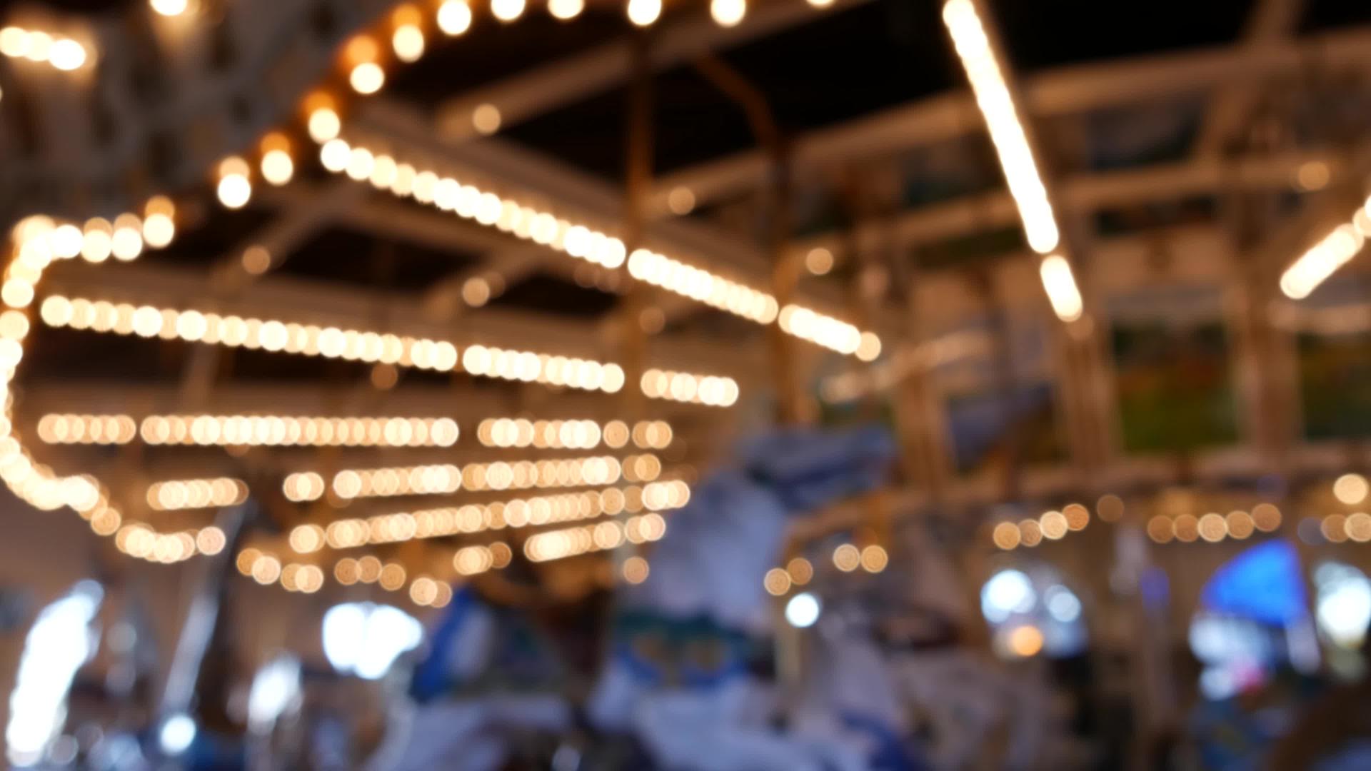 金色照明散焦复古旋转木马在游乐园旋转模糊闪亮的旋转视频的预览图