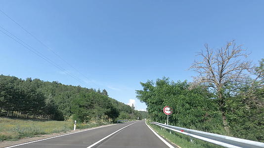 汽车驱动器的第一个视角是乡村沥青路和蓝天相对于汽车旅行视频的预览图