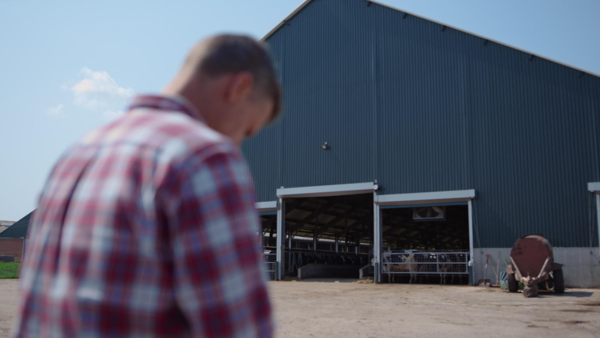 农场工人坐在农田牧场附近的谷仓外视频的预览图