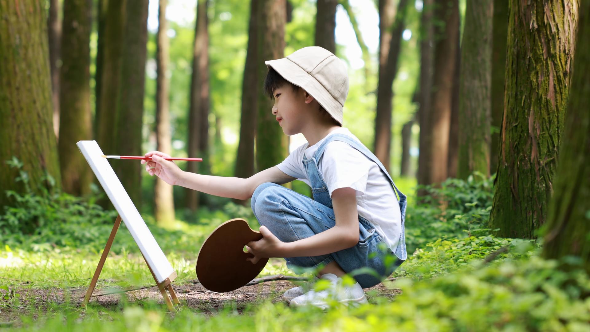 男孩在树林里画画视频的预览图