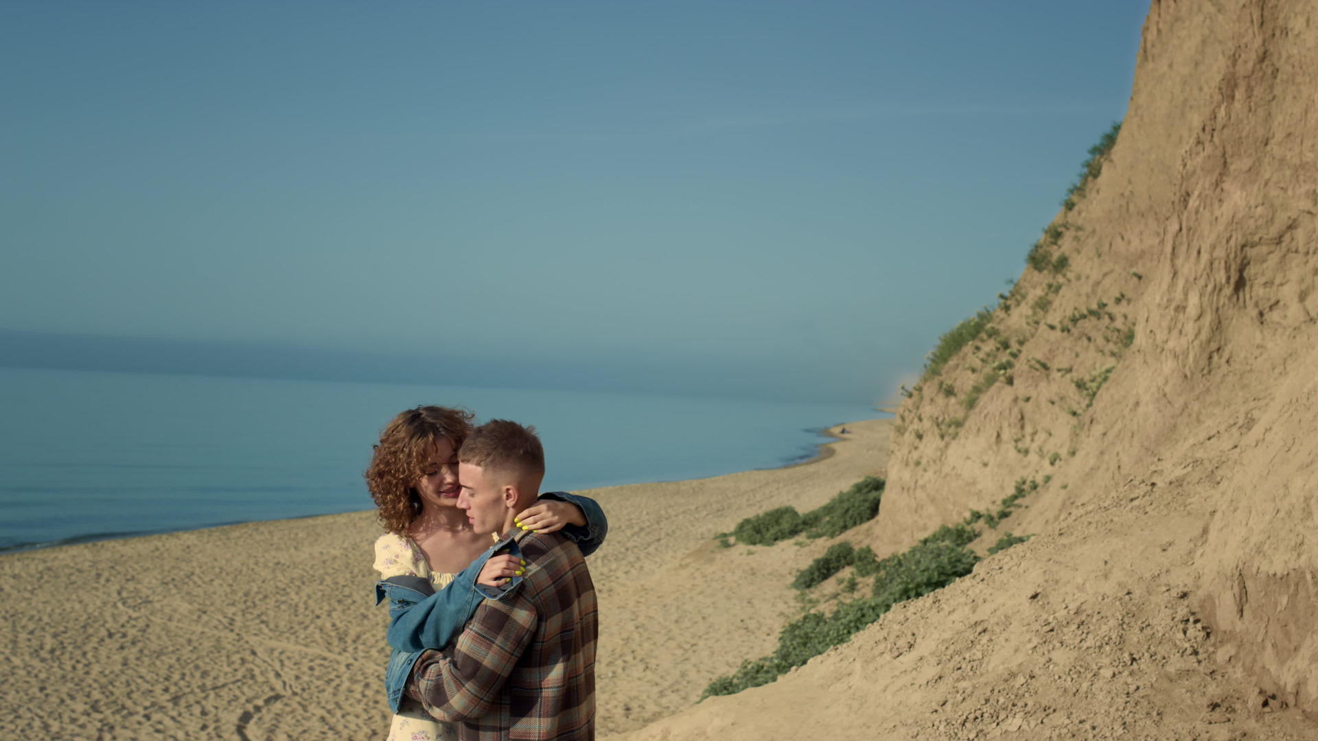 快乐的一对拥抱沿着海滩沿着海岸线行走视频的预览图