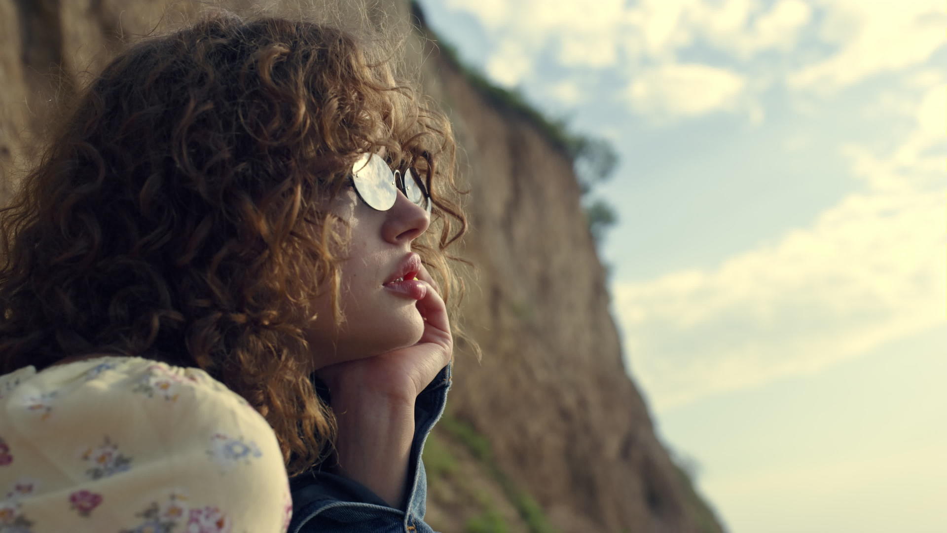 梦幻般的女人肖像坐在海边的太阳镜上视频的预览图
