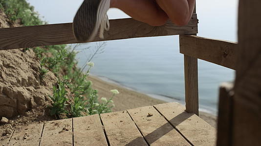 不知名的女孩腿白运动鞋在海边楼梯上玩得很开心视频的预览图
