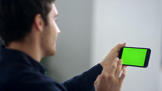 在绿屏移动电话上以慢动作的方式进行热烈的视频对话视频的预览图