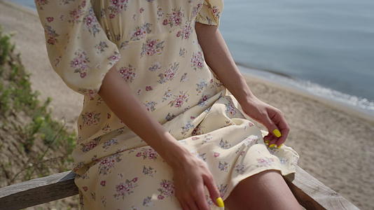 一位可爱的女士穿着华丽的裙子在沙滩上放松视频的预览图