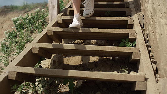 身材苗条的女孩穿着白色运动鞋跑下沙滩楼梯视频的预览图