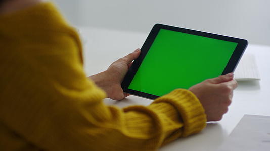 女商人用绿色屏幕握住平板电脑视频的预览图