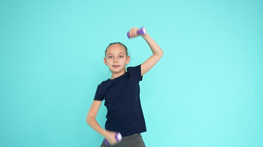 快乐的女孩在有氧健身房用翡翠举起哑铃视频的预览图