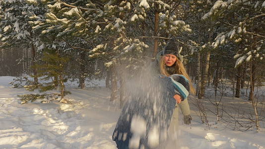 快乐的男女青少年在冬季度假期间在森林里打雪球视频的预览图