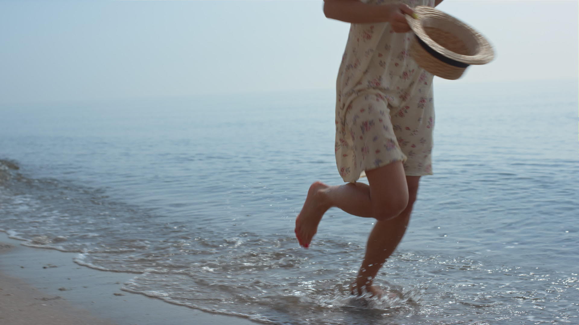 苗条的女孩在夏天带着帽子跑海水视频的预览图
