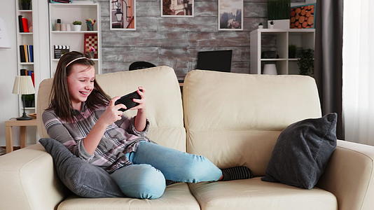 快乐的小女孩玩电子游戏视频的预览图