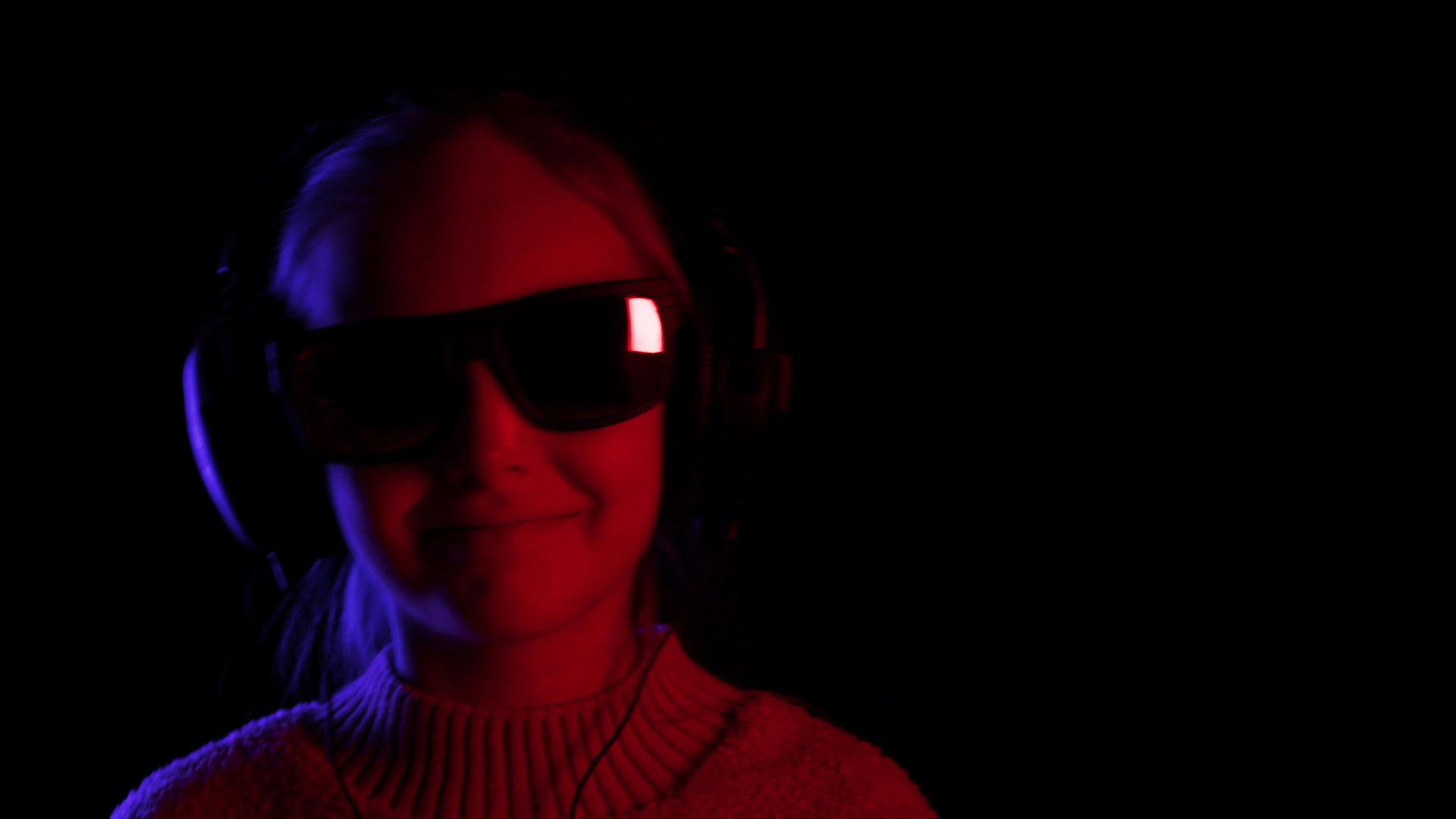 一个女孩戴着黑色太阳镜和耳机在黑色工作室听音乐视频的预览图