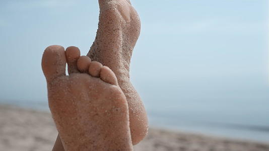 裸露的女人脚上沾满了沙滩和沙滩视频的预览图