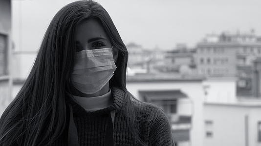 女性的黑白肖像戴着面具对抗看相机慢动视频的预览图