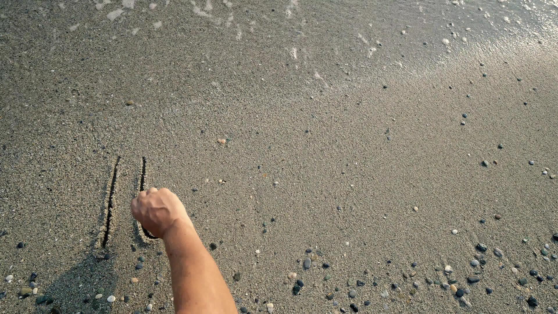 海滩上写着被海浪冲洗的字眼视频的预览图
