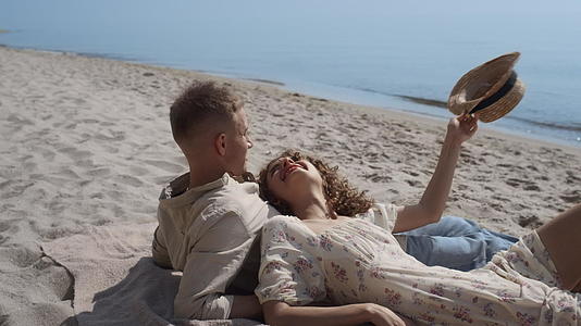 无忧无虑的夫妇躺在沙滩上的夏日时光视频的预览图