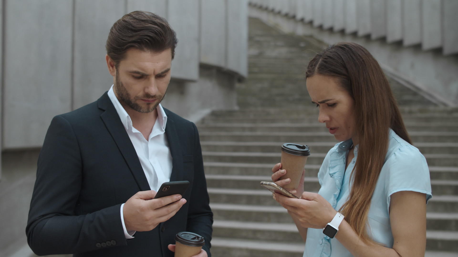 商务男女在街上喝咖啡处理手机文件视频的预览图