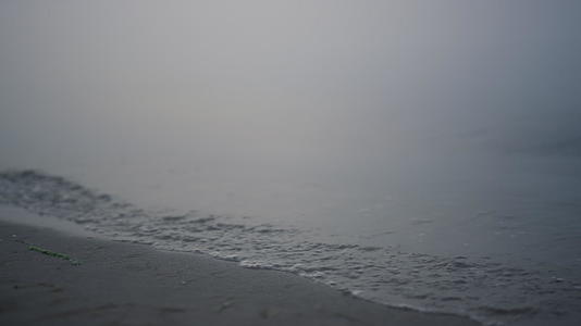 日出时特写海浪冲刷沙滩视频的预览图