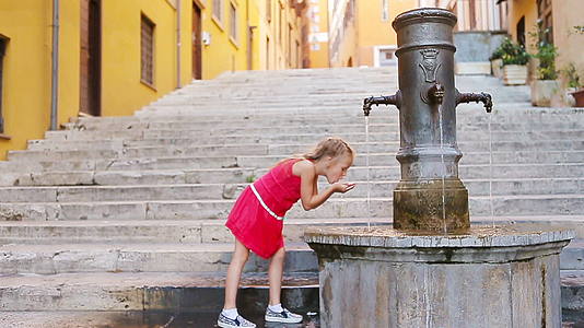 可爱的小女孩从水龙头喝水视频的预览图