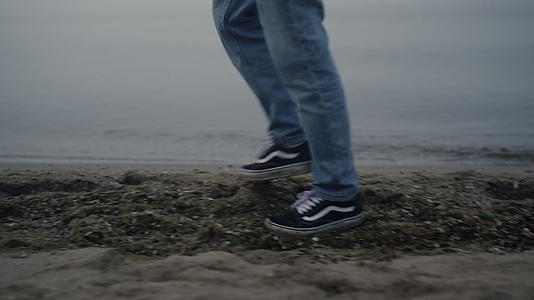 走在海边特写镜头里的休闲运动鞋视频的预览图