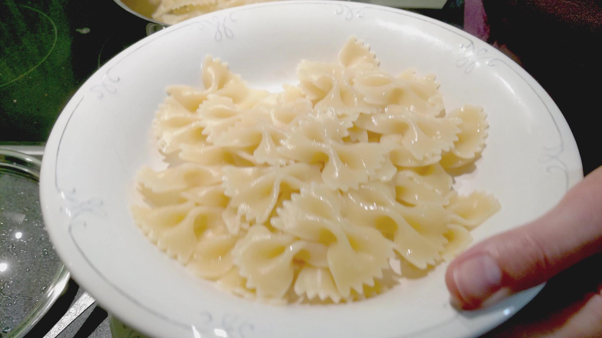 女人把意大利面放在盘子上视频的预览图