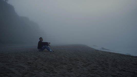 悲伤的人在雾中看海景视频的预览图