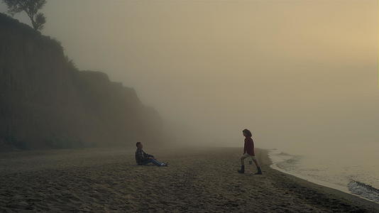 日出时年轻夫妇在沙滩上放松视频的预览图