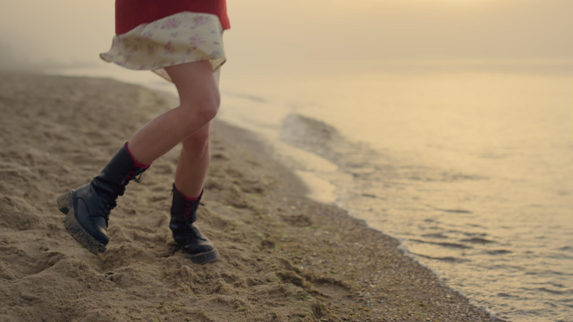 时尚女孩在沙滩上跳跃的靴子视频的预览图